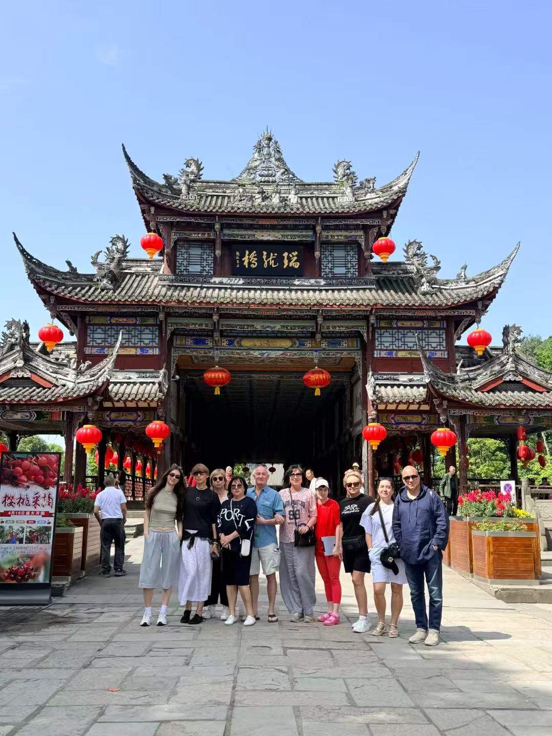 Travel group in front of the ancient Ruilong covered bridge in Sichuan