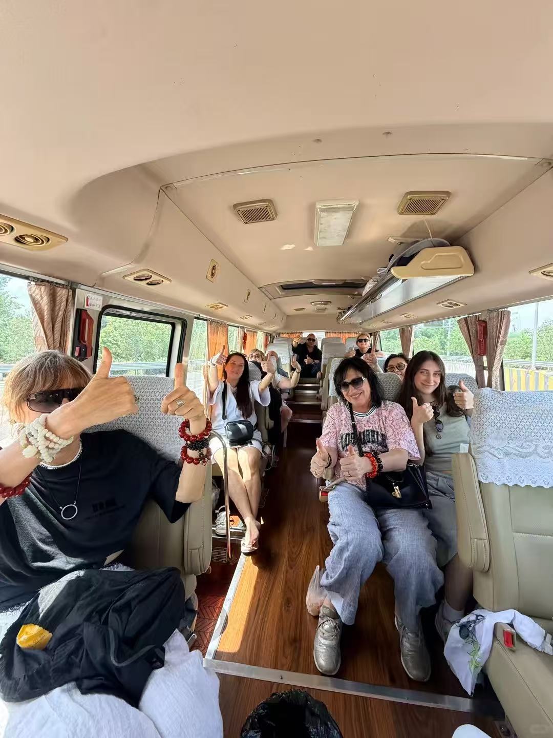International travel group giving thumbs up on a comfortable tour bus in China